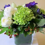 Flowers used: white roses, blue anemones, white amaryllis, green hydrangeas, red hypericum berries