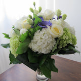 Flowers used: white roses, green and white hydrangeas, green chrysanthemums, purple ranunculus, white lisianthus