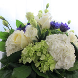 Flowers used: white roses, green and white hydrangeas, green chrysanthemums, purple ranunculus, white lisianthus