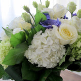 Flowers used: white roses, green and white hydrangeas, green chrysanthemums, purple ranunculus, white lisianthus