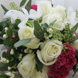 Flowers used: white roses, white orchids, pink celosias, seeded eucalyptus, white berries