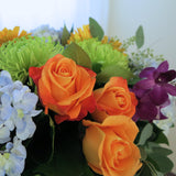 Flowers used: orange roses, orange gerberas, blue hydrangeas, green chrysanthemums, purple orchids, seeded eucalyptus