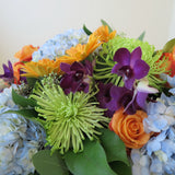 Flowers used: orange roses, orange gerberas, blue hydrangeas, green chrysanthemums, purple orchids, seeded eucalyptus