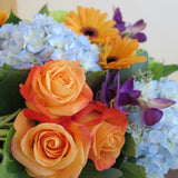 Flowers used: orange roses, orange gerberas, blue hydrangeas, green chrysanthemums, purple orchids, seeded eucalyptus