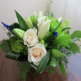 Flowers used: cream roses, white lilies, green chrysanthemums, blue irises