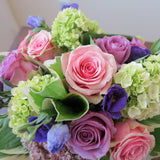 Flowers used: green hydrangeas, pink and mauve roses, blue lisianthus, pink sedums, hosta leaves
