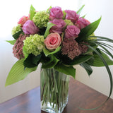 Flowers used: green hydrangeas, pink and mauve roses, blue lisianthus, pink sedums, hosta leaves