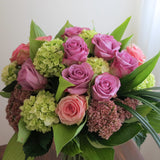 Flowers used: green hydrangeas, pink and mauve roses, blue lisianthus, pink sedums, hosta leaves