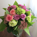 Flowers used: green hydrangeas, pink and mauve roses, blue lisianthus, pink sedums, hosta leaves