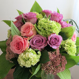 Flowers used: green hydrangeas, pink and mauve roses, blue lisianthus, pink sedums, hosta leaves