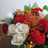 Flowers used: cream roses, white lisianthus, red celosias, orange protea, orange berries
