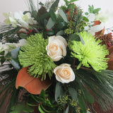 Flowers used: white orchids and white roses, green chrysanthemums, magnolia leaves, seeded eucalyptus, white pine