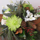 Flowers used: white orchids and white roses, green chrysanthemums, magnolia leaves, seeded eucalyptus, white pine
