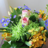 Flowers used: blush pink roses, orange orchids, red tulips, green chrysanthemums, blue aster daisies