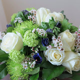 Flowers used: white roses, green chrysanthemums and viburnums blue/purple anemones, wax flowers, seeded eucalyptus