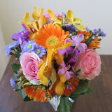 Flowers used: blush pink roses, orange gerberas, yellow, orange and mauve orchids, blue aster daisies