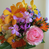 Flowers used: blush pink roses, yellow, orange and mauve orchids, orange gerberas, blue daisies