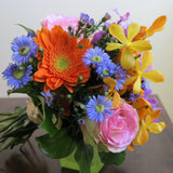 Flowers used: blush pink roses, yellow, orange and mauve orchids, orange gerberas, blue daisies