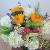 Flowers used: soft white and green hydrangeas, warm yellow sunflowers, rusty pink sedums