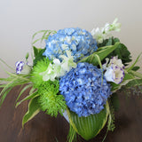 Flowers used: blue hydrangeas, purple/white lisianthus, white orchids, green chrysanthemums, hosta leaves and green kales