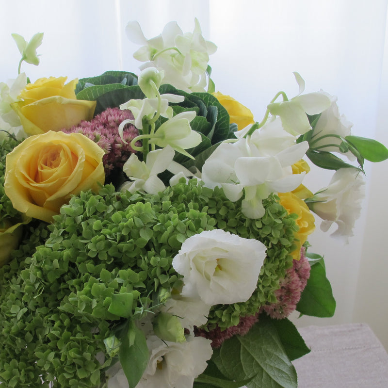 Flowers used: green hydrangeas, yellow roses, white lisianthus, white orchids, pink sedums, green kales