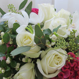 Flowers used: white roses, white orchids, pink celosias, seeded eucalyptus, white berries