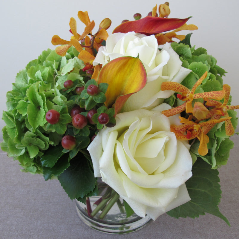 Flowers used: white roses, orange calla lilies, orange mokara orchids, green hydrangeas, hypericum berries
