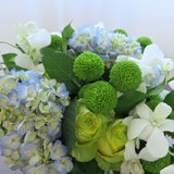 Flowers used: white roses, blue hydrangeas, white orchids, green mini mums