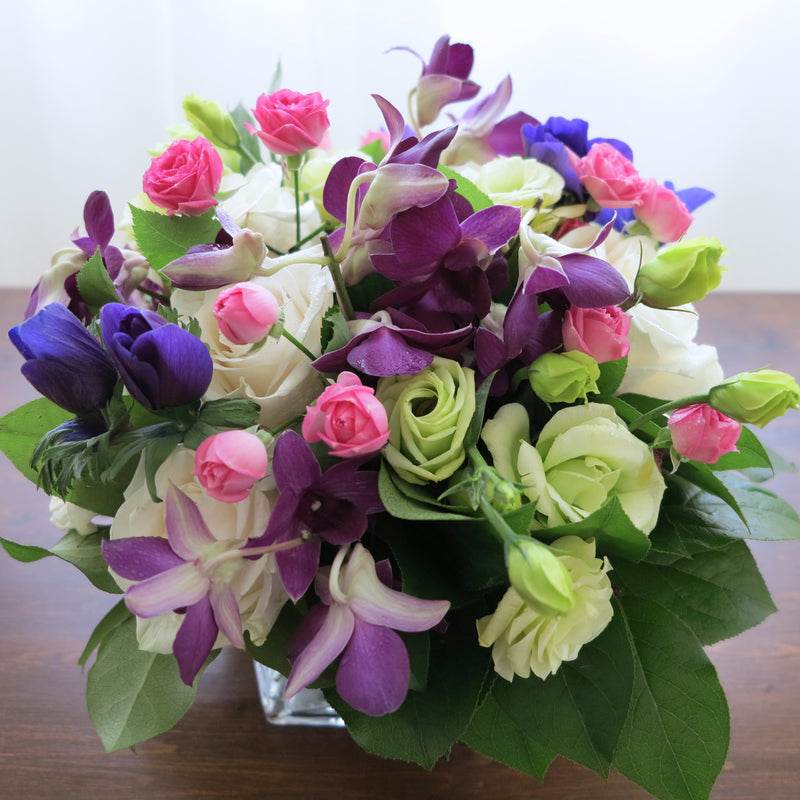 Flowers used: cream white roses, white gerberas, chartreuse lisianthus, blue anemones, pink mini roses, purple orchids