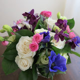 Flowers used: cream white roses, white gerberas, chartreuse lisianthus, blue anemones, pink mini roses, purple orchids