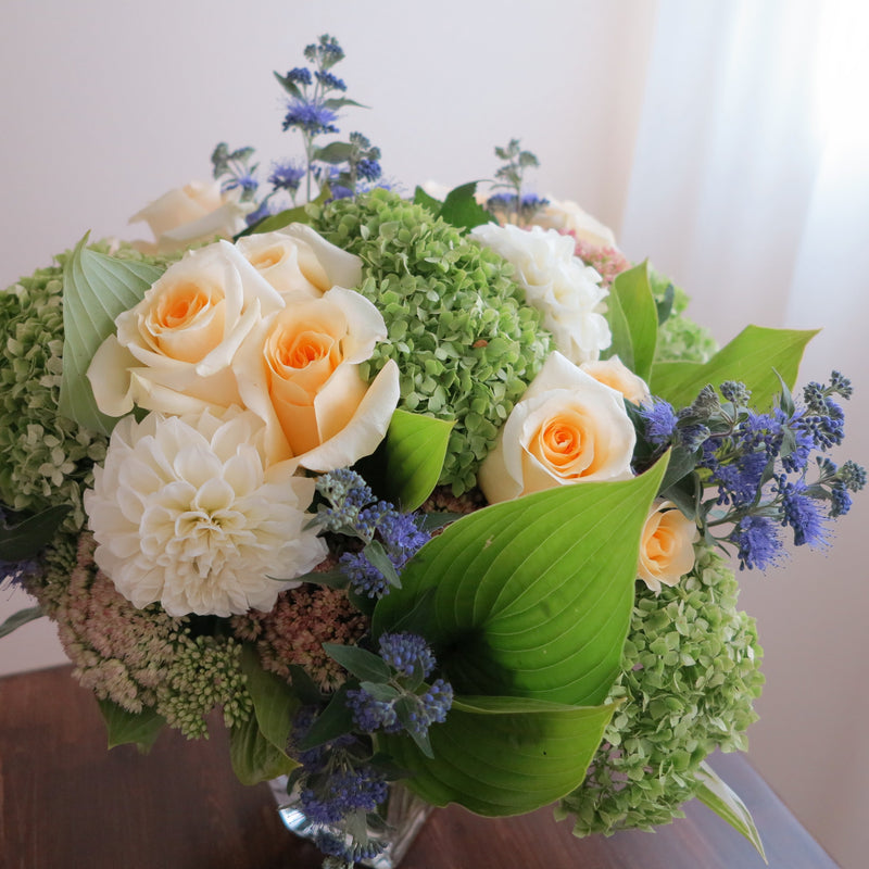 Flowers used: green hydrangeas, cream roses, white dahlias, blue spirea, pink sedums, hosta leaves