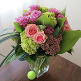 Flowers used: green hydrangeas, pink and mauve roses, blue lisianthus, pink sedums, hosta leaves