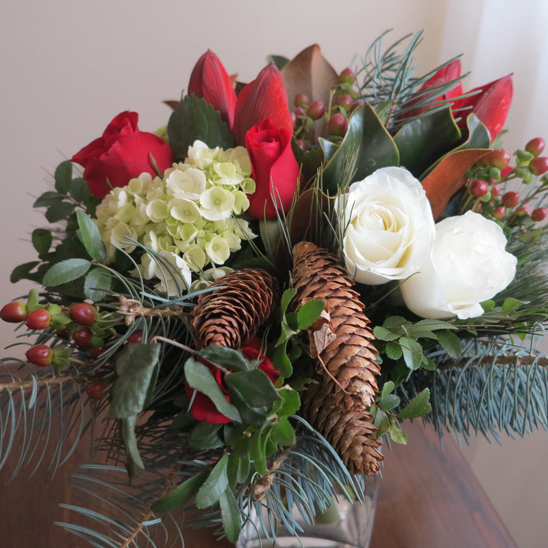 Flowers uses: white roses, red roses, red amaryllis, chartreuse hydrangea, red hypericum berries, magnolia leaves