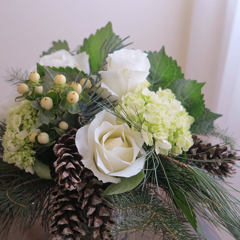 Flowers uses: white roses, red roses, chartreuse hydrangea, white hypericum berries, white pine cones