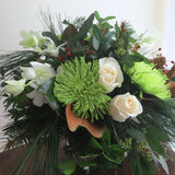 Flowers used: white orchids and white roses, green chrysanthemums, magnolia leaves, seeded eucalyptus, white pine