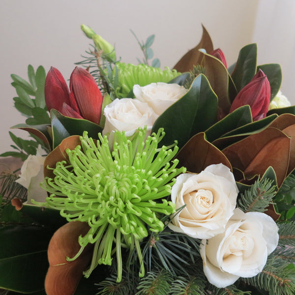 Flowers used:  cream roses, green chrysanthemums, red amaryllis, white lisianthus, magnolia leaves, evergreens boughs