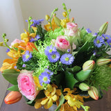 Flowers used: blush pink roses, orange orchids, red tulips, green chrysanthemums, blue aster daisies