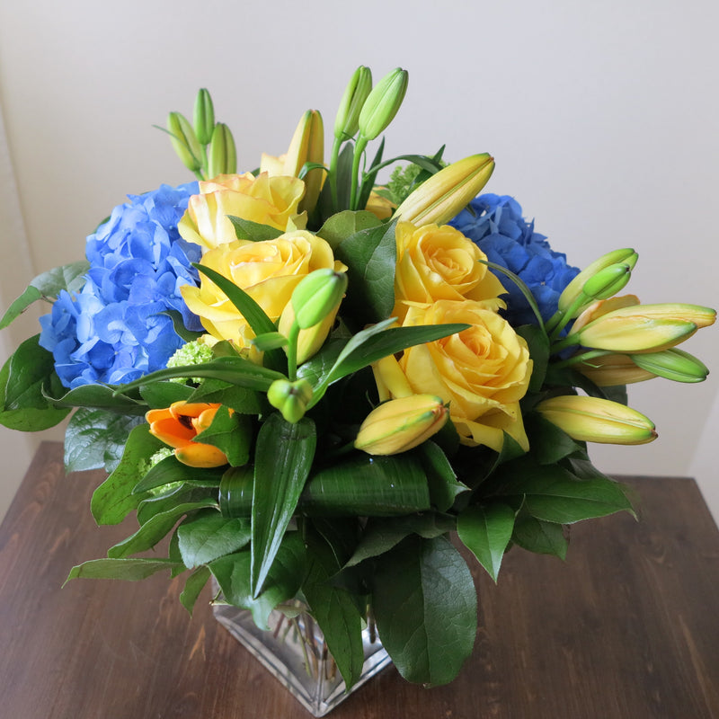 Flowers used: yellow roses, blue hydrangeas, yellow lilies and green viburnums