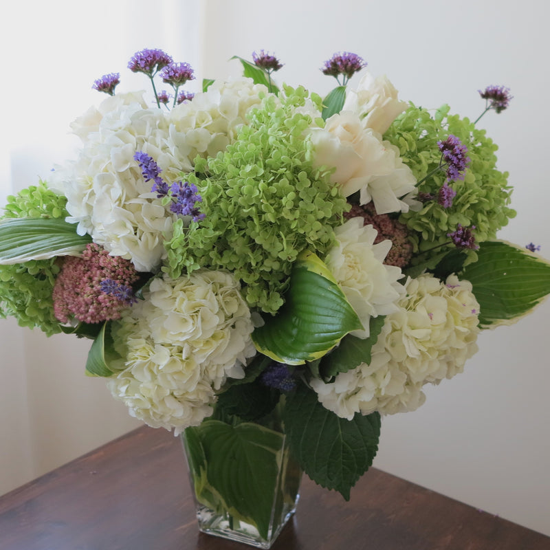 Flowers used: green and white hydrangeas, cream roses, white dahlias, blue verbena and lavender, pink sedums, hosta leaves