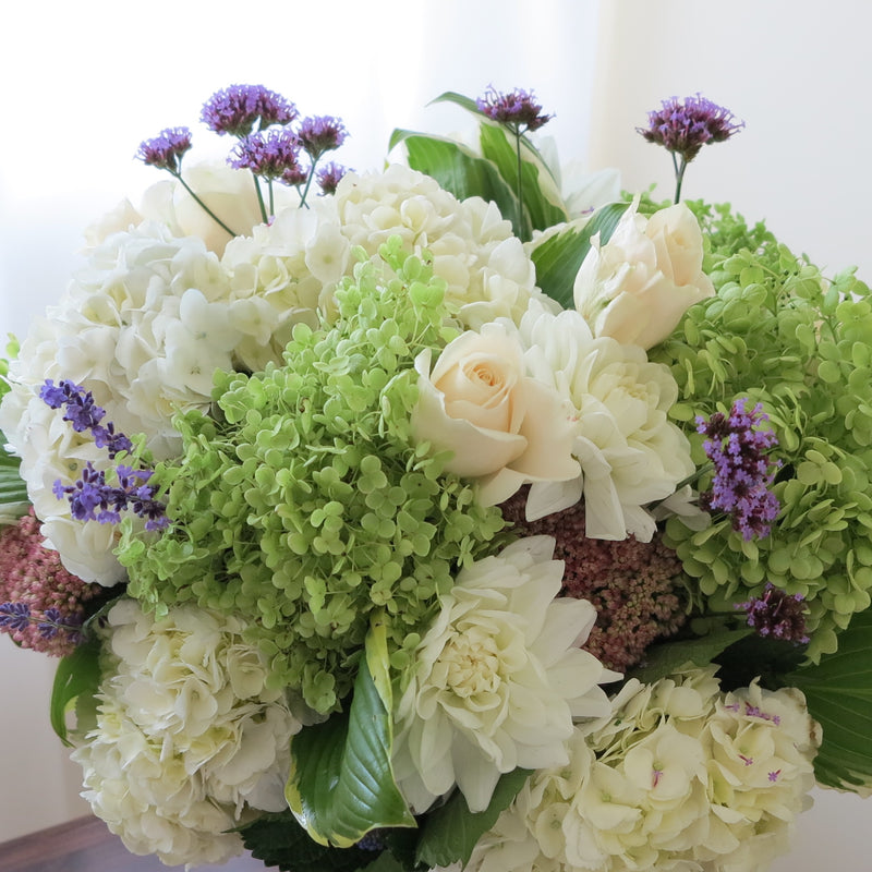 Flowers used: green and white hydrangeas, cream roses, white dahlias, blue verbena and lavender, pink sedums, hosta leaves