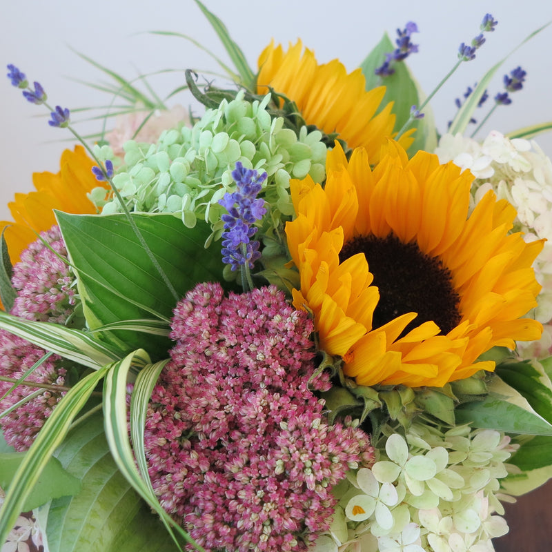 Flowers used: soft white and green hydrangeas, warm yellow sunflowers, rusty pink sedums