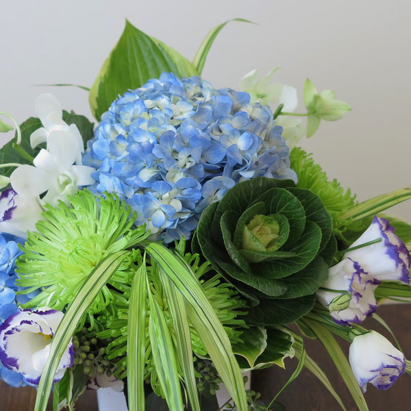 Flowers used: blue hydrangeas, purple/white lisianthus, white orchids, green chrysanthemums, hosta leaves and green kales