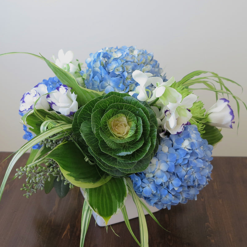 Flowers used: blue hydrangeas, purple/white lisianthus, white orchids, green chrysanthemums, hosta leaves and green kales