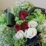 white and burgundy roses, green hydrangeas, purple anemone, blue lisianthus